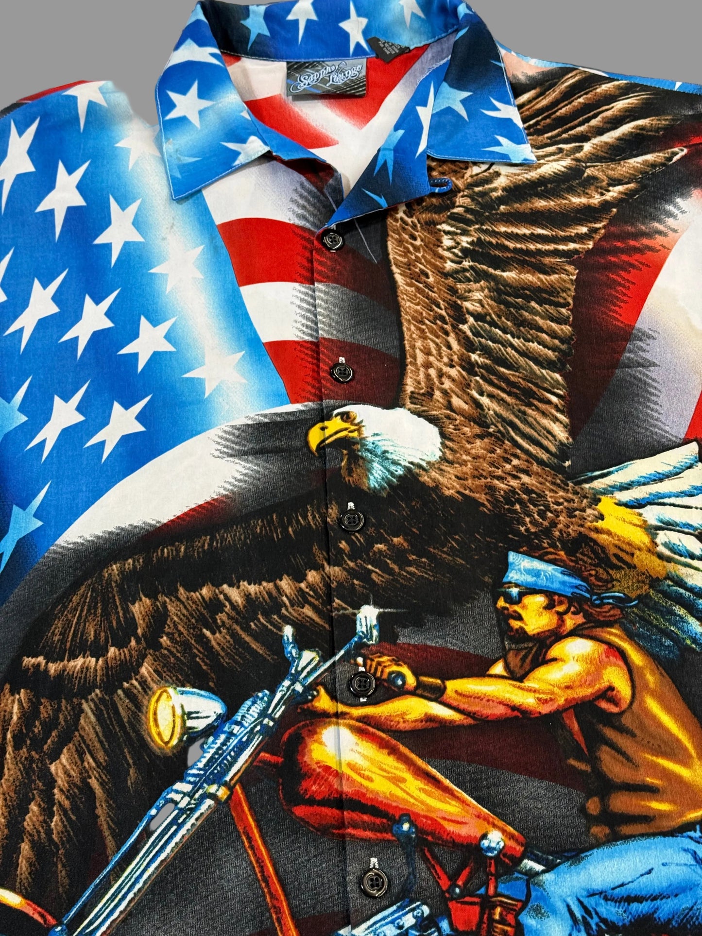 Shirt with American flag design and eagle graphic on a motorcycle.