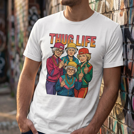 Close-up of golden thug life T-shirt's printed design on model near graffiti wall emphasizing fabric and print detail.